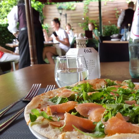 My Salmon pizza with arugula on Garden Risto's patio seating